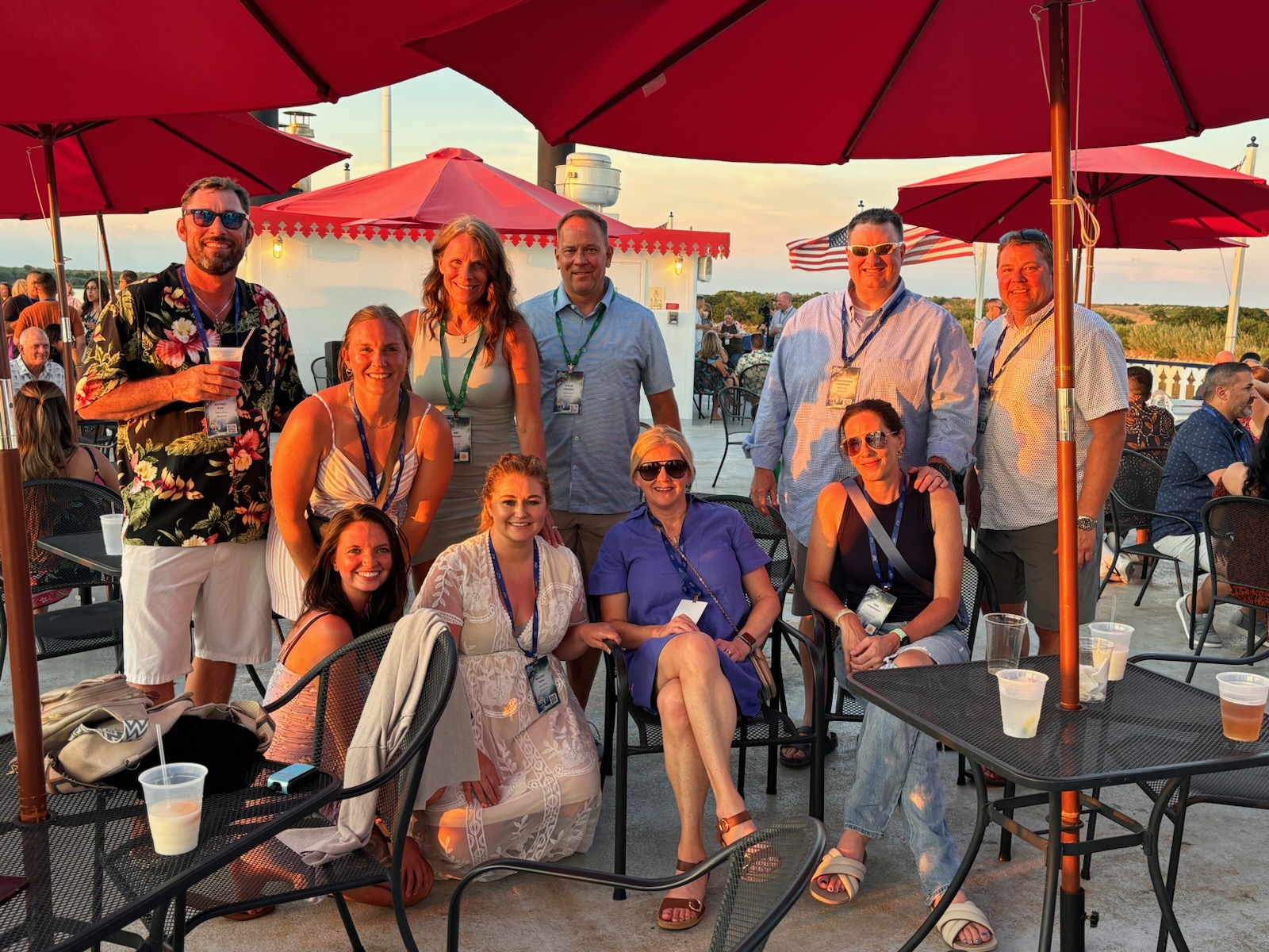 Team members gathered beneath red umbrellas on vacation