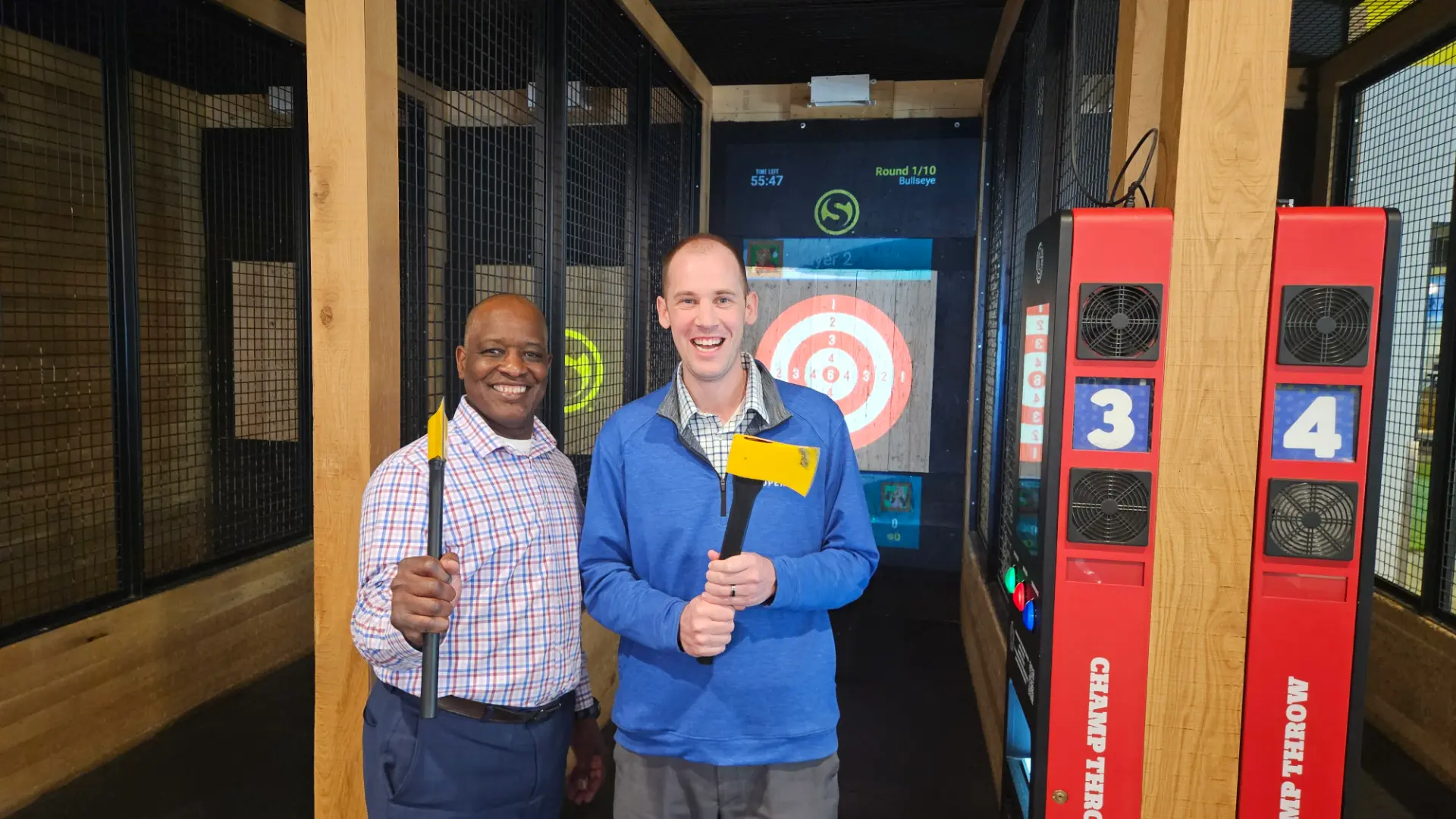 Two Team Twin Cities members at an axe-throwing team event